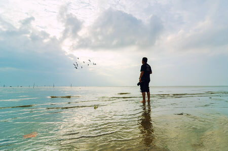 Photographer looking to the ray of light in the morningの写真素材