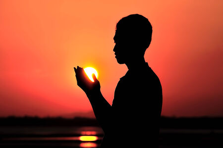 Praying at sunsetの写真素材