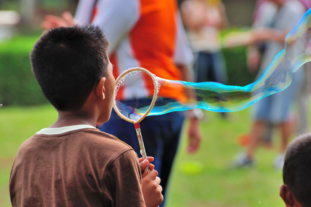 PAHANG, MALAYSIA - MARCH 29, 2014 : Kids playing with giant bubble at Putrajaya Hot Balloon Fiesta 2014 located at Putrajaya, Malaysia.のeditorial素材