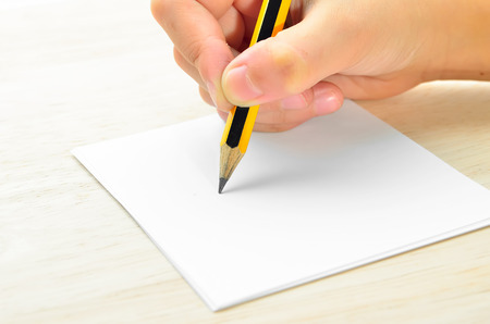 Pencil in hand writing on paper