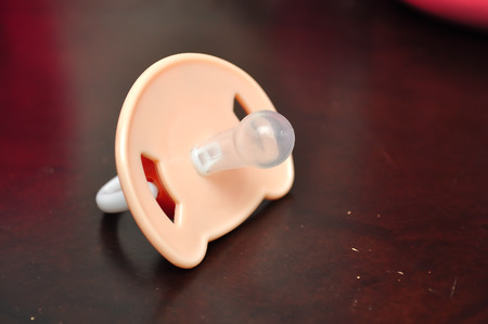 Baby silicone pacifier on wood backgroundの写真素材