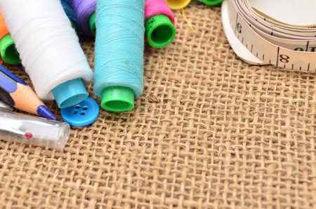 Sewing kit. Scissors, bobbins with thread and needles on the old fabric
