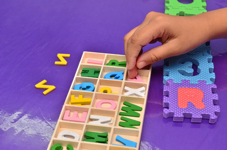 Child's hands playing with alphabet