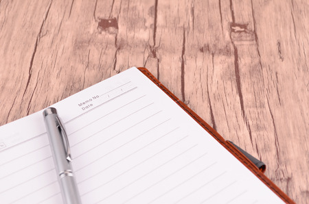 Pen and notepad on wooden tableの写真素材