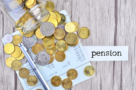 Coins and silver pen on bank account book with label Pensionの写真素材