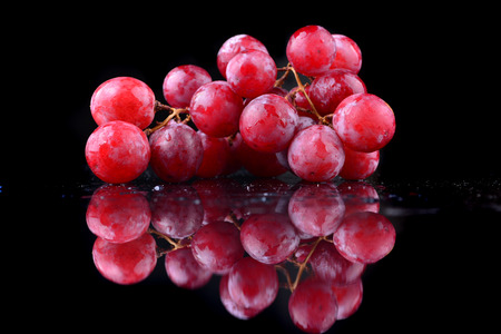 bunch of red grapes isolated on black backgroundの写真素材