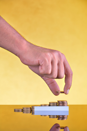 Hand put coin use for money financial banking conceptの写真素材