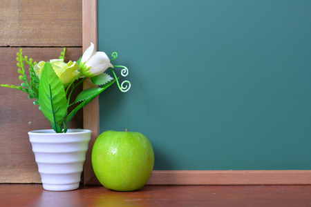 Green chalkboard on wooden backgroundの写真素材
