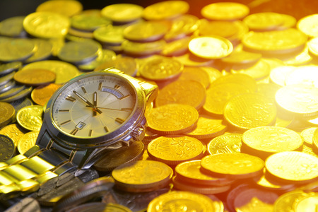 clock and stacks of coins : time - moneyの写真素材