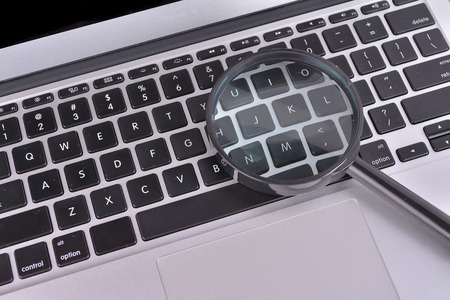 Laptop computer with magnifying glass, concept of searchの写真素材