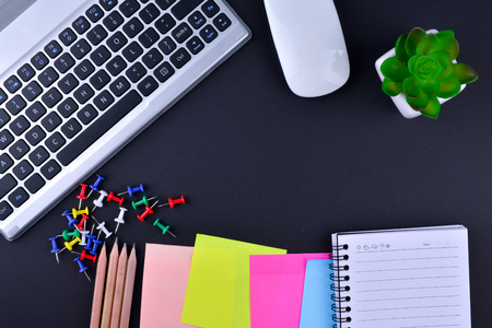 Laptop and notebook  on black tablesの写真素材