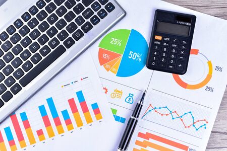 Laptop and pen with business charts, graphs, statistic and documents background for education and...