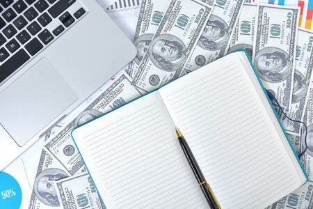 Business Concept. Laptop, graph and banknote dollars with notebook and penの写真素材