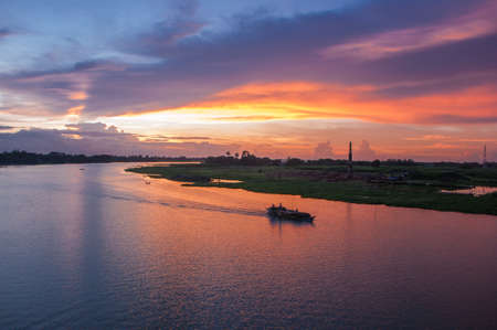 Aerial view of cargo ship on the river at sunset. Freight transportation concept.