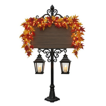 A black metal signpost with ornate scrollwork supports a rectangular wooden sign. The sign is adorned with a vibrant garland of red and orange maple leaves intertwined with warm white string lights. Two decorative lanterns with faux candle flames hang from the lower part of the post. The entire display is set against a white background.の素材