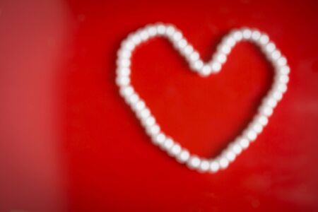 Pearl necklace heart on red background.の写真素材