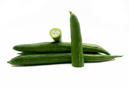 Fresh green unripe tomato isolated on yellow background.