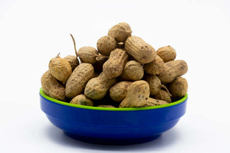 dry Unpeeled peanuts close up isolated on white background.
