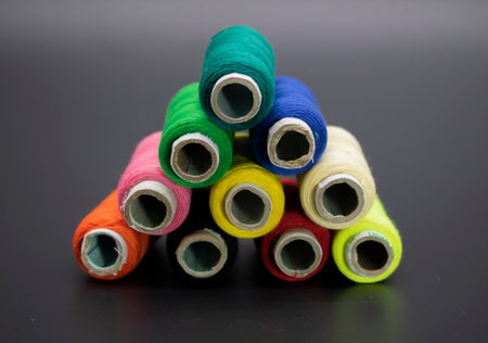 Group of whole haberdashery item colorful thread spools isolated on black background. Coloured...