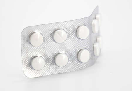 round white pills in packaging sheets on white background, close up, medicine, tablet
