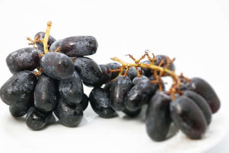 Black grapes with drop of water isolated on white backgroundの写真素材