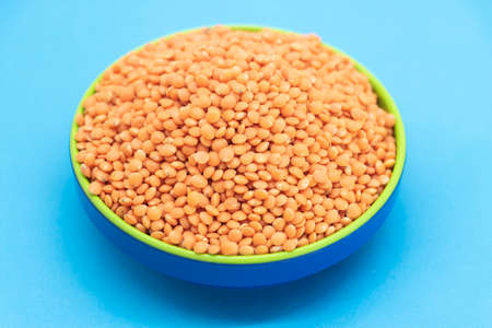 Red lentils pile isolated on blue background, also known as Dry orange lentil grains, masoor dhal,の写真素材