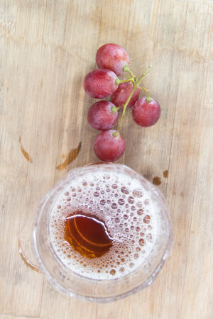 glass of wine with grapes isolated on wooden background, top viewの写真素材