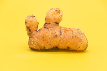 turmeric isolated on yellow backgroundの写真素材