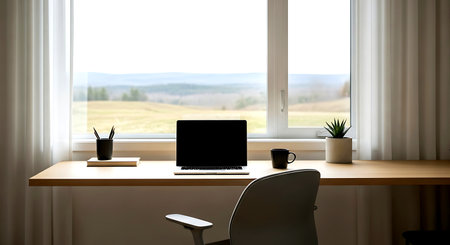 Workplace with laptop on wooden table in front of panoramic windowの素材