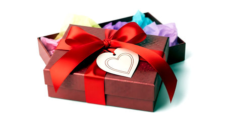 Gift box with red bow and heart on a white background.の素材