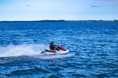 Miami, Florida/USA, 07/17/2020 - Man jet skiing near the coast of Brickell Key Park in Miami, Florida, Man riding a jet ski in Miami, FL, Male riding jet ski in Brickell Miami, Life jacket,のeditorial素材