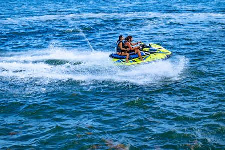 Miami, Florida/USA, 07/17/2020 -Couple jet skiing near the coast of Brickell Key Park in Miami, Florida, Man and woman riding a jet ski in Miami, FL, People wearing a life jacket on jet skiのeditorial素材