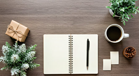 Inspiring top-down view of a winter workspace featuring a hot coffee, notebook, and indoor plants, creating a productive and cozy atmosphere for creative tasks.の写真素材