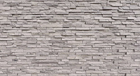 Detailed natural stone wall surface showing variations in brown and yellow colored rocks