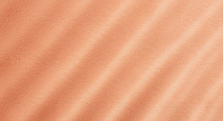 Luxurious background featuring a fuzzy peach-pink velvet material. Directional lighting creates depth and highlights the soft, plush texture of the fabric, offering a warm and inviting visual.の写真素材