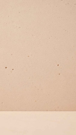 A clean and minimalist beige background featuring subtle speckled dots. This high-quality texture...