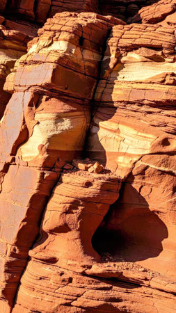 A detailed macro view of red sedimentary rock layers shaped by millions of years of erosion. The...