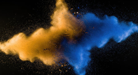 A dynamic explosion captures vibrant orange and blue smoke clouds swirling against a dark backdrop creating a striking contrast between the warm fiery hues and cool electric tones rendered in sharp detail with a sense of motion and energy.の写真素材