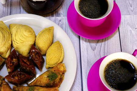 Eastern Turkish sweets baklava and cup of coffee on wooden tableの写真素材