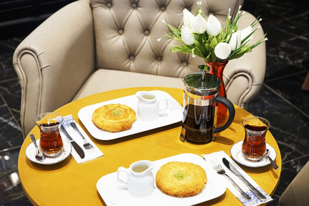 kettle, cups with tea and Eastern Turkish sweets on the table in a cafeの写真素材