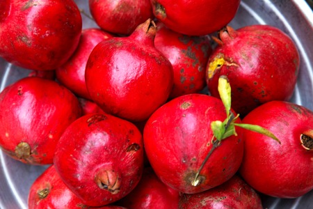 red ripe delicious grenades lying on the groundの写真素材