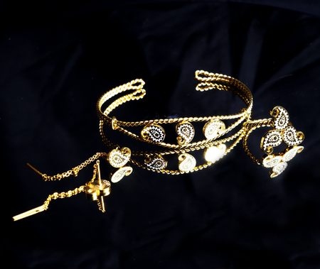 female Golden Eastern Turkish vintage women's handmade jewelry on a black background.earrings, bracelets, rings, pendantsの写真素材