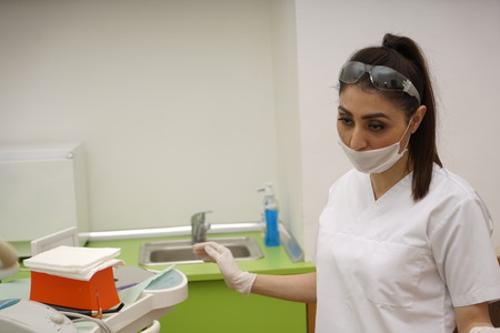 Female dentists examining and working on young male patient.Dentist's office.の写真素材
