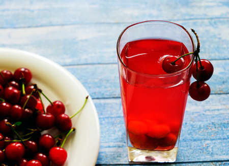 Glass of stewed sweet cherry fruit on the table