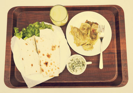 vegetarian dish cutlets of vegetables in the dough, stuffed vegetables, kefir with herbs and lemon juice on a brown tray on the tableの写真素材