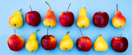 yellow red ripe apples and pears on blue background, healthy eatingの写真素材
