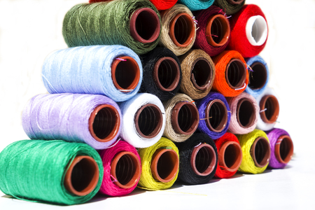 Multi-color silk thread coils on white background.