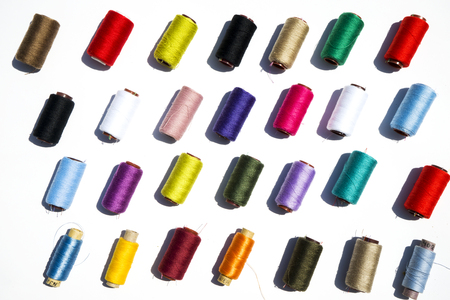 Multi-color silk thread coils on white background.