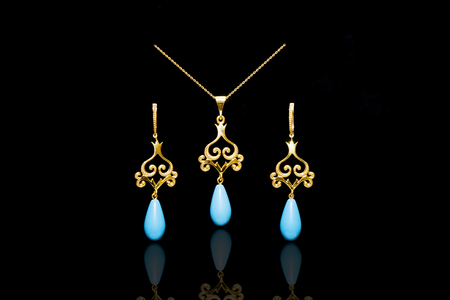 Golden Eastern Turkish vintage women's handmade jewelry on a black background. Earrings, rings and pendantsの写真素材