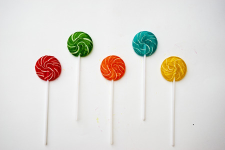 Colorful candies and lollipops with stick isolated on white backgroundの写真素材
